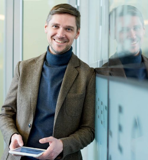 smiling-businessman-holding-tablet-VCLGQ6R