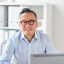 happy-businessman-in-eyeglasses-with-laptop-office-2021-08-26-22-51-50-utc