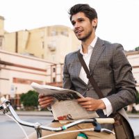 business-man-holding-newspaper-on-a-bicycle-2021-08-29-02-45-35-utc